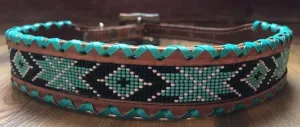Genuine leather dog collar ith teal, white, and black navajo beaded inlay design, a rawhide wrapped edge